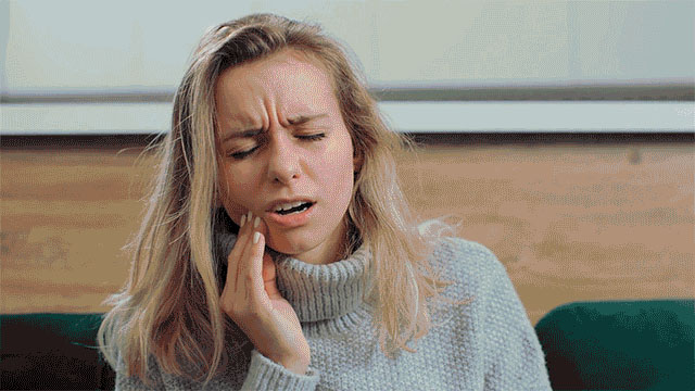 Young woman with tooth discomfort